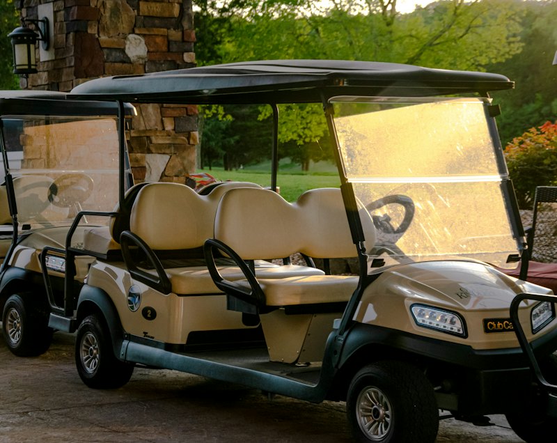 Golf carts with windshields parked on a course