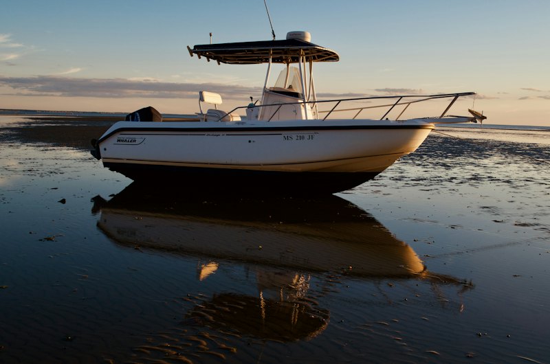 Center-console boat with a T-top canvas at golden hour